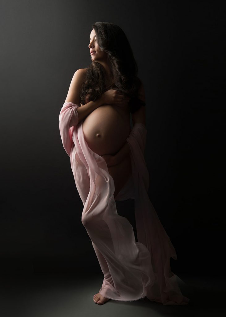 pregnant woman standing flowing fabric