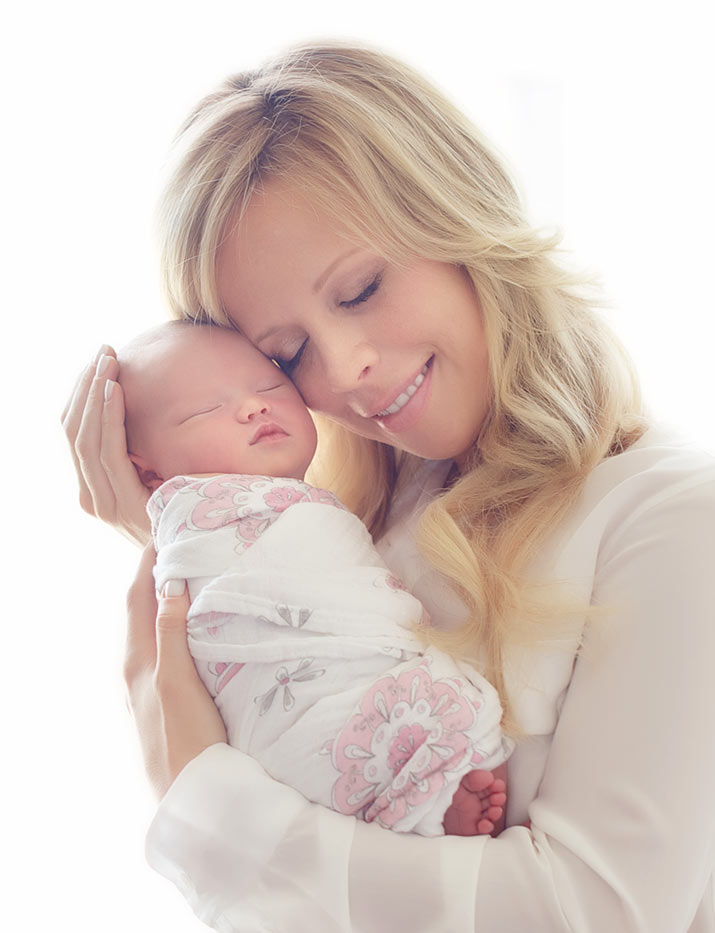 Mother holding her newborn baby in a swaddle.