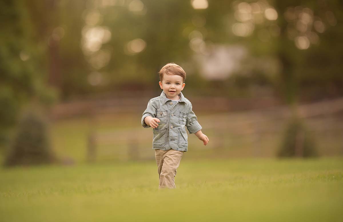 Happy boy running through a farm field.