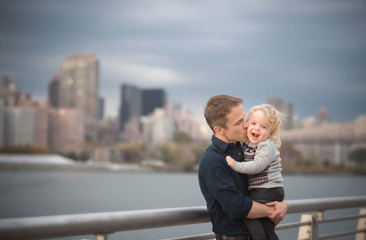 Dad kissing his little boy near the East River NYC.