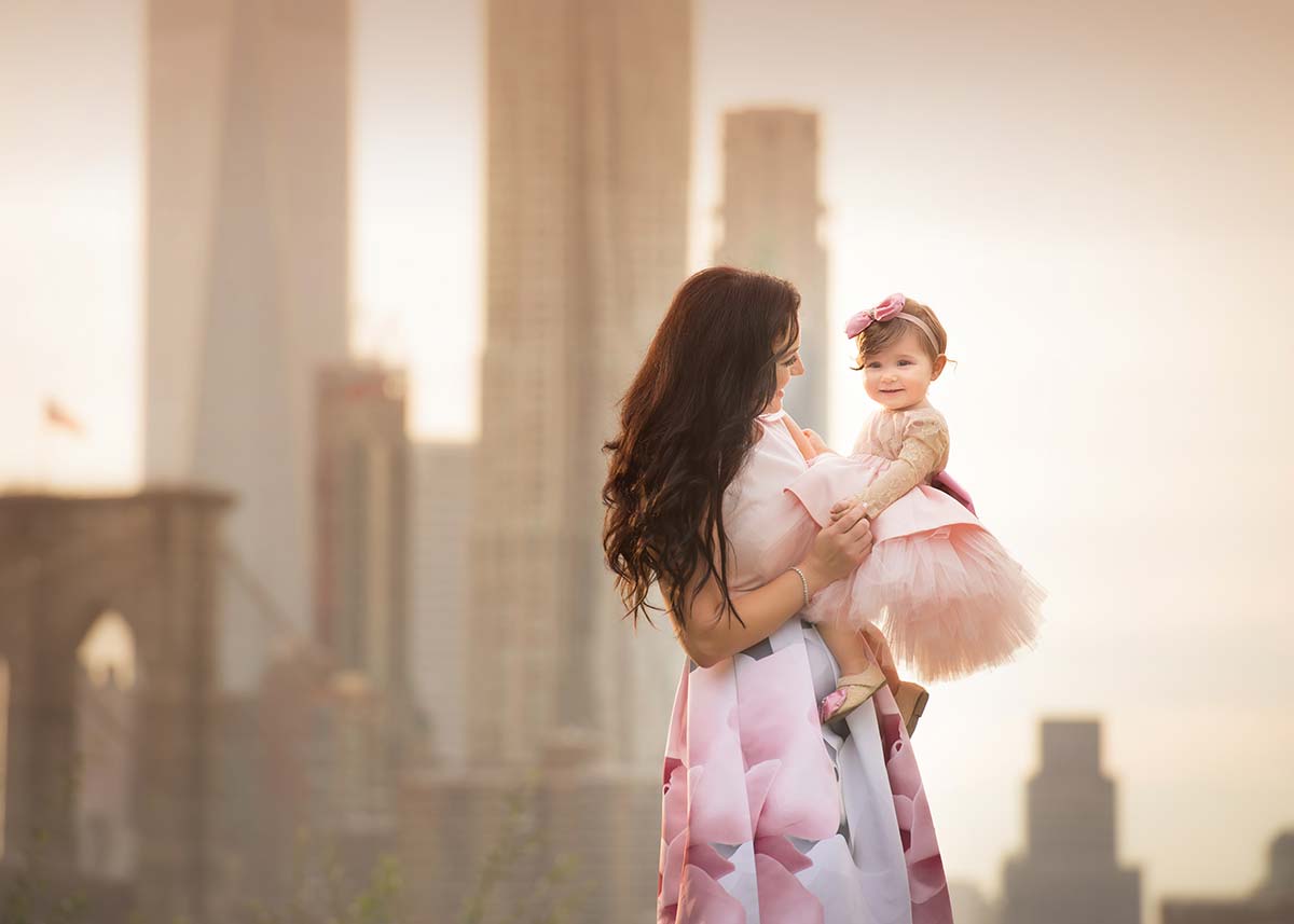 A mother and daughter posing by downtown NYC.