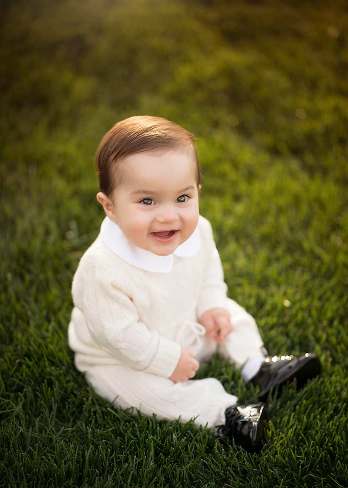Photo of a young toddler smiling beautifully in grass