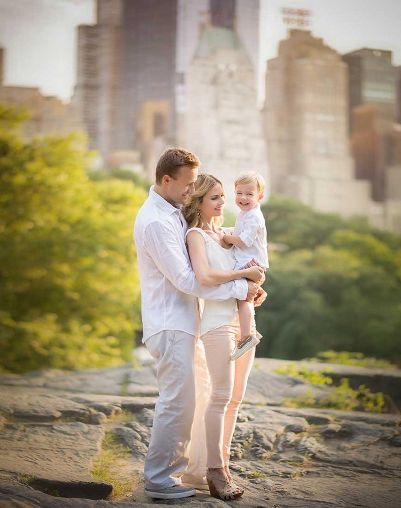 A modern family dressed in white posing in Central Park, NYC.