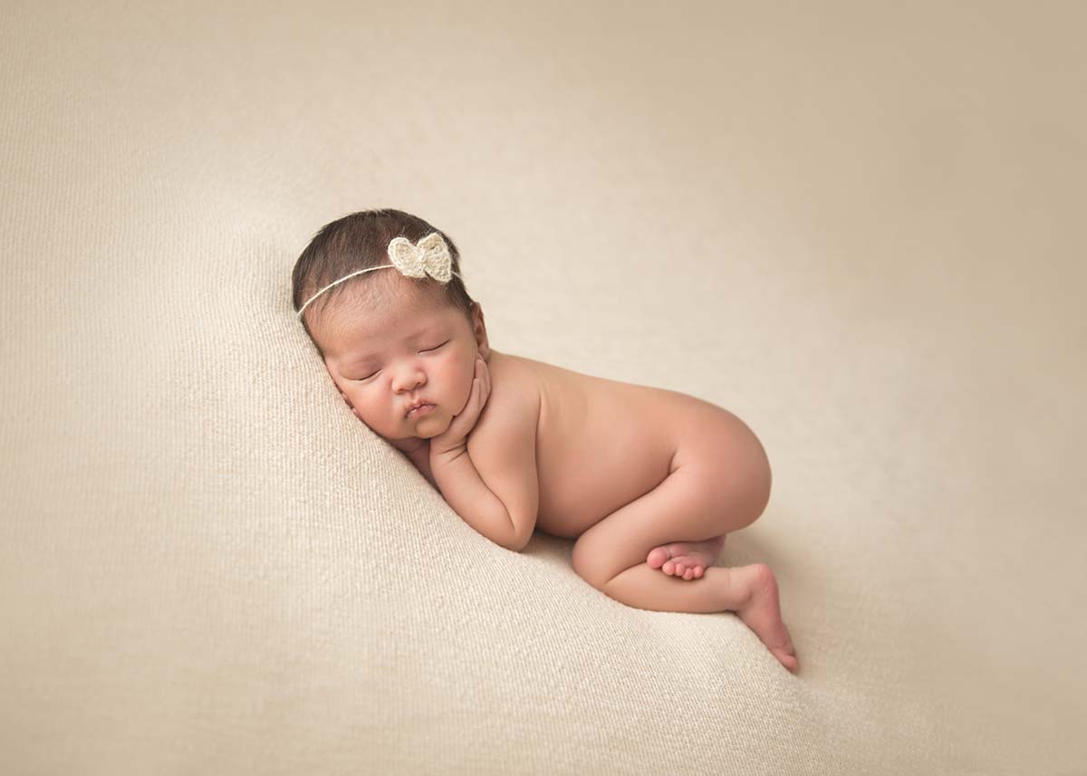 Beautiful infant sleeping with her hands on her cheeks