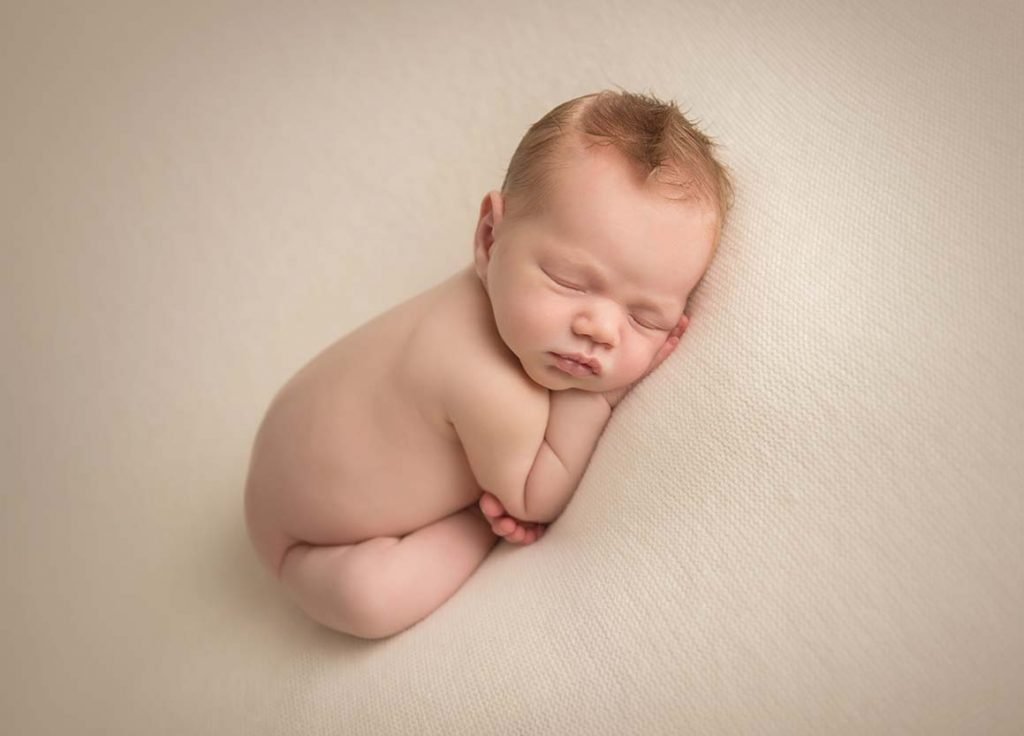 infant curled up in sweet pose for newborn portraits in Manhattan studio