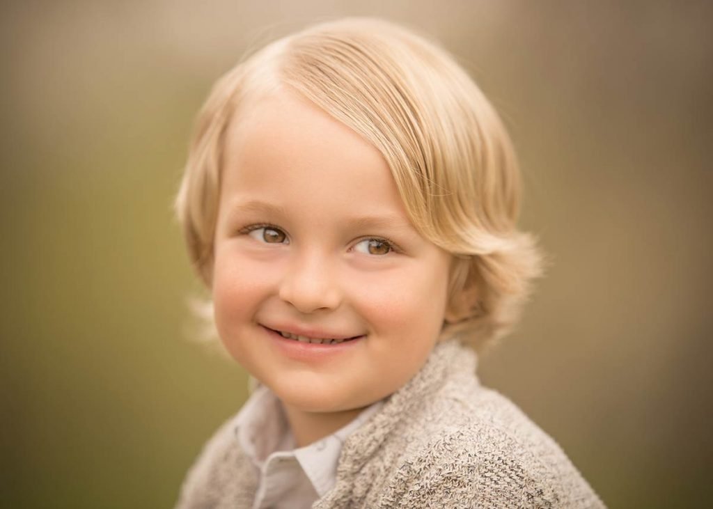 Closeup portrait of a boy with blonde hair smiling