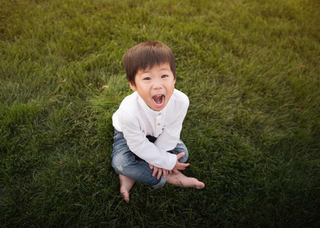 Boy smiling while sitting in grass
