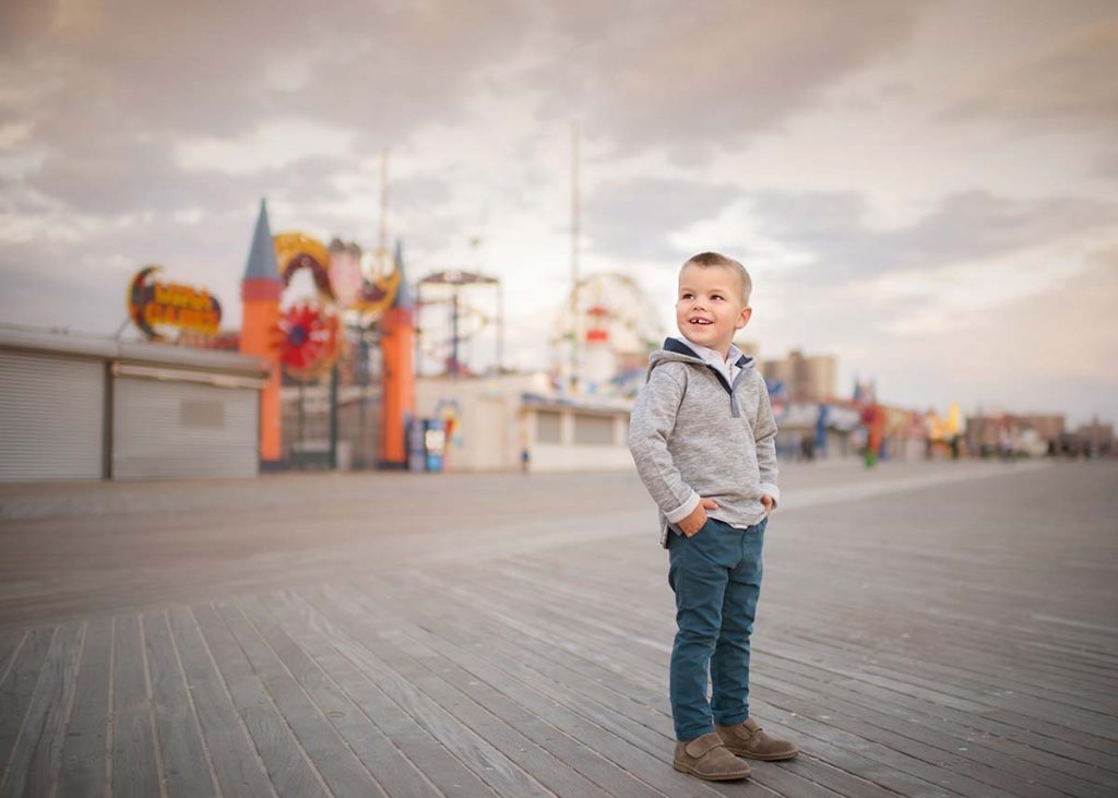 Boy standing on a pier in Coney Island, NYC
