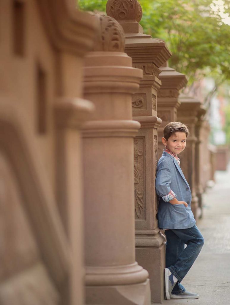 Stylish boy standing near a brownstone townhouse in NYC
