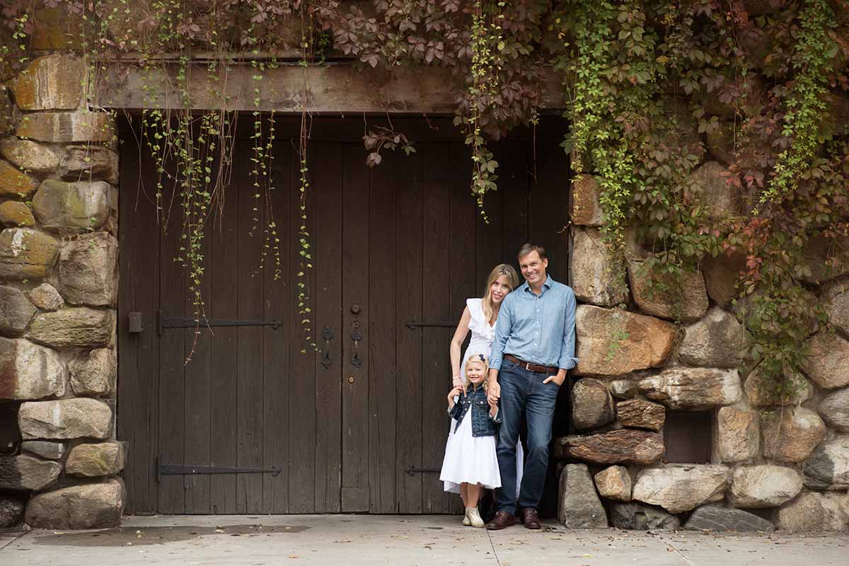 Stylish family posing near a barn door