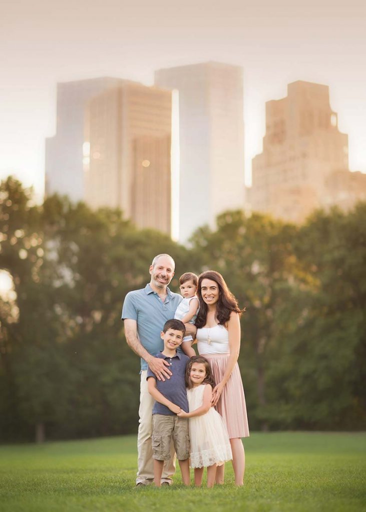 Modern family posing for a portrait in NYC's Sheep Meadow