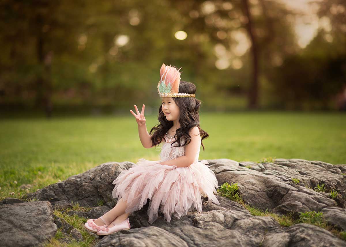 Girl wearing a native american headband and a tutu posing for a picture