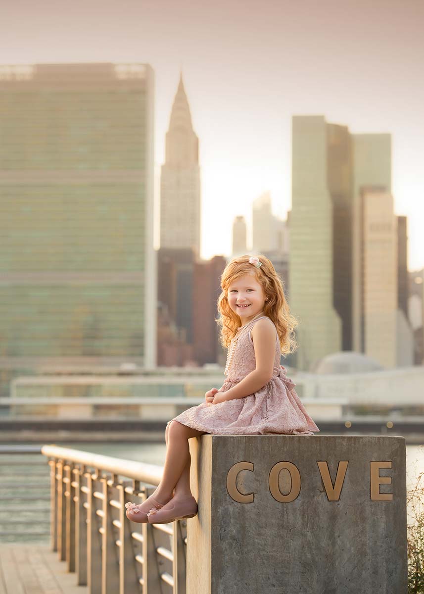 Girl with red hair and a tutu posing with Chrysler building in the background