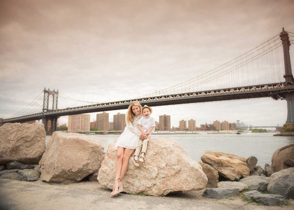 Stylish Mom posing with her son near Manhattan Bridge, NYC