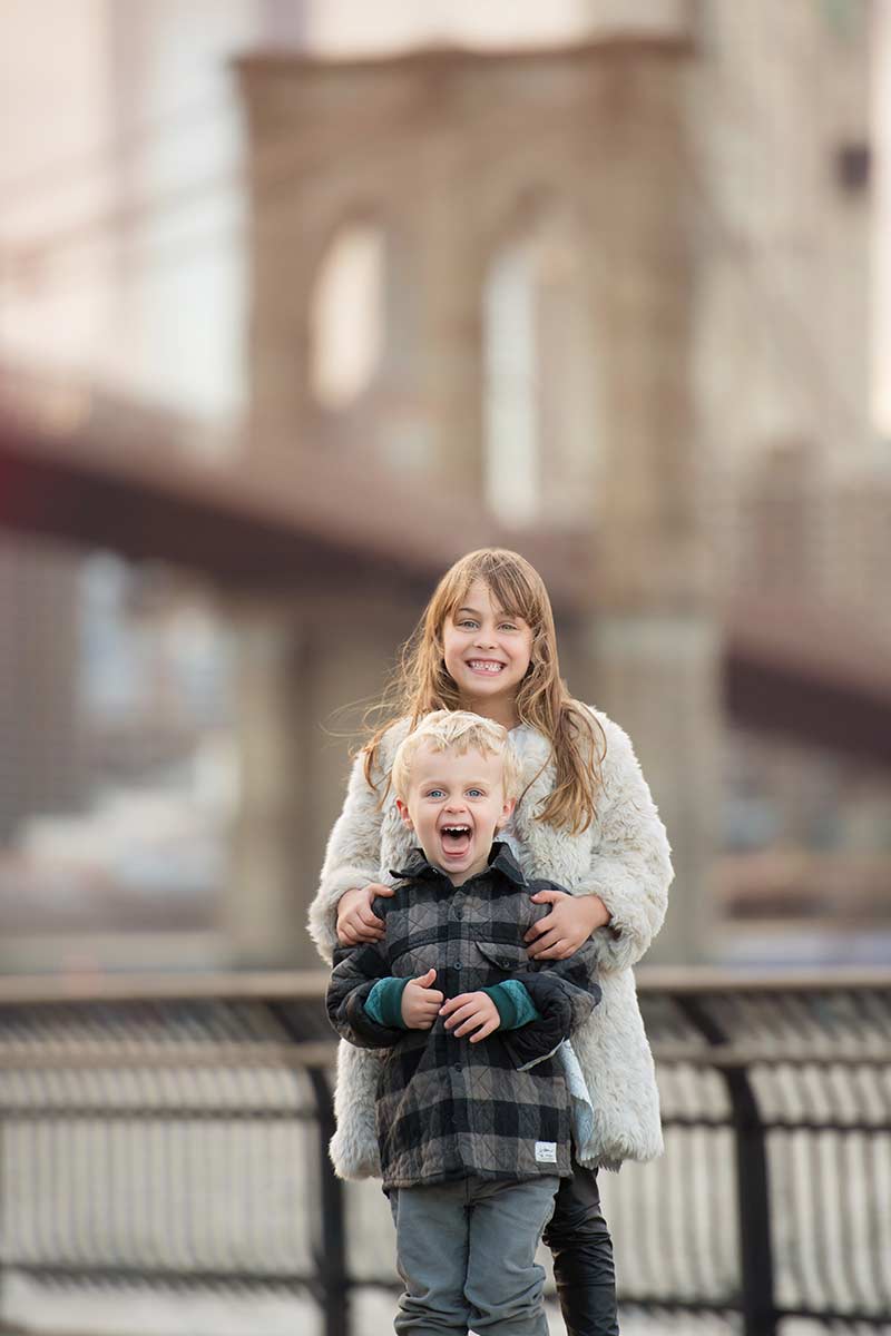 Brother and sister standing near East River in NYC