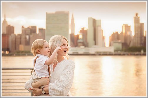 Mother holding her son at a riverside park near East River, NYC