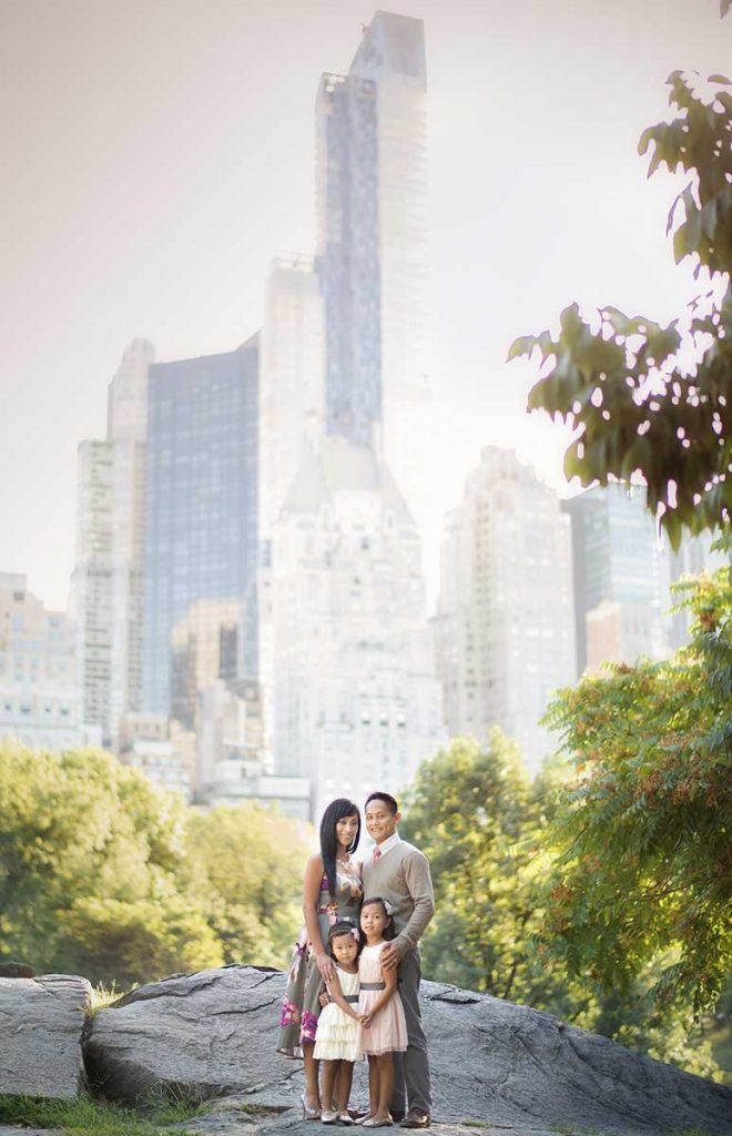 Family portrait set in NYC's Central Park with Manhattan skyline in the background