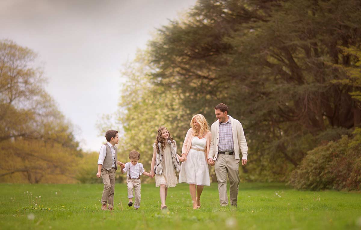 Lifestyle portrait of a beautifully styled family walking in a grass field