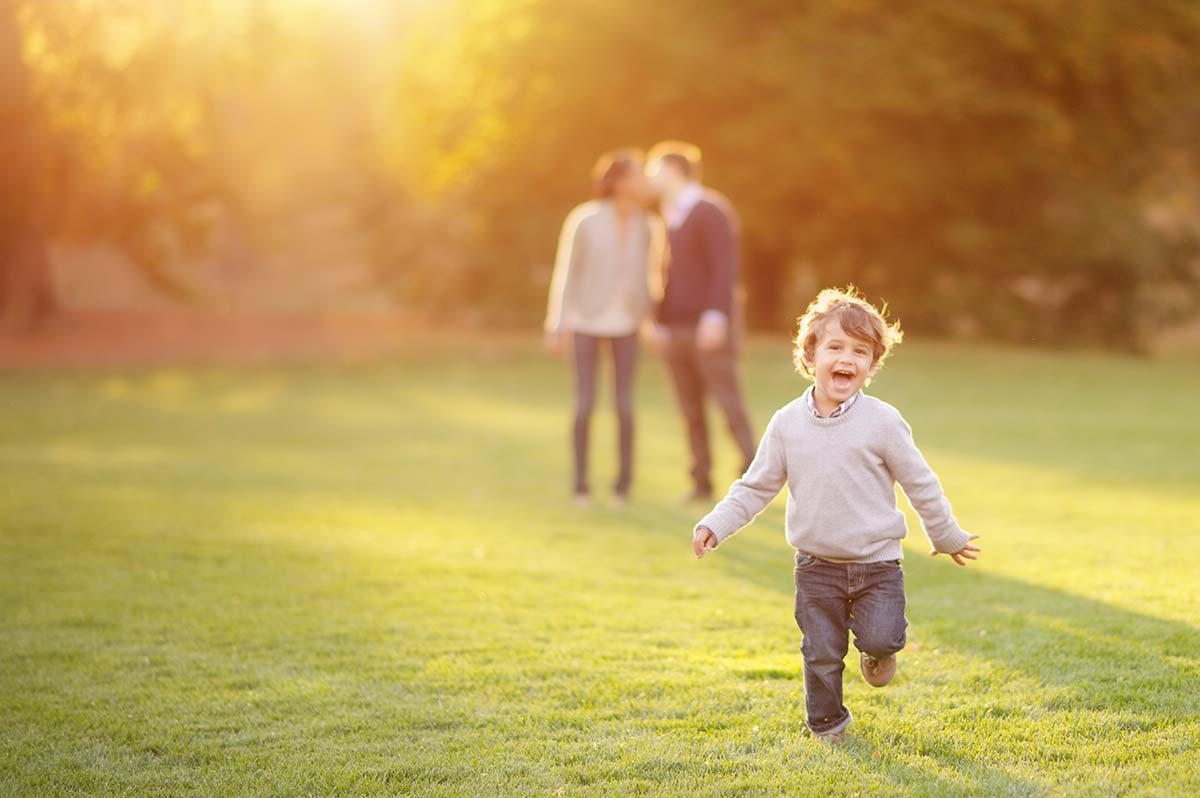 Happy boy running through a grass field in NYC
