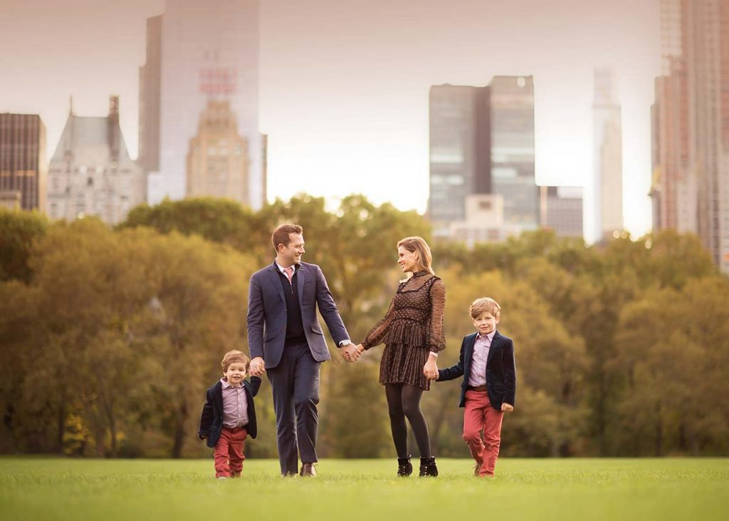 Stylish Manhattan Family walking in Central Park's Sheep Meadow and sharing a happy moment