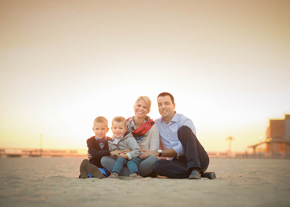 Stylish family posing for a photo at the beach during sunset