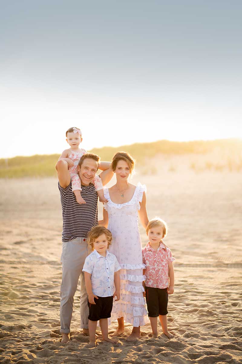 Married couple with children posing for a family portrait on the beach