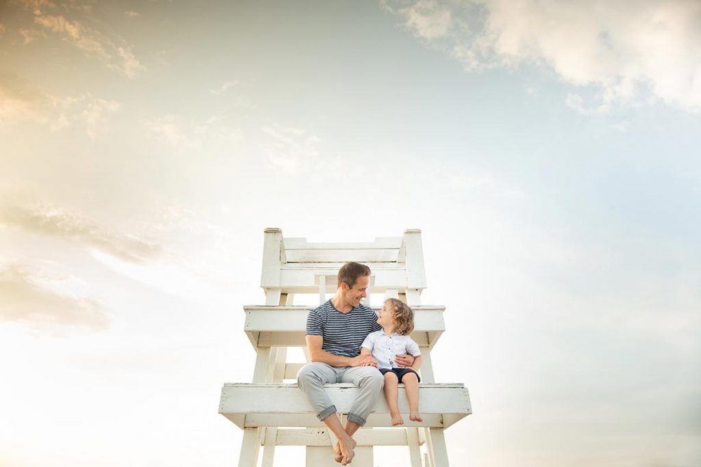 Father sitting on a lifeguard tower with his son