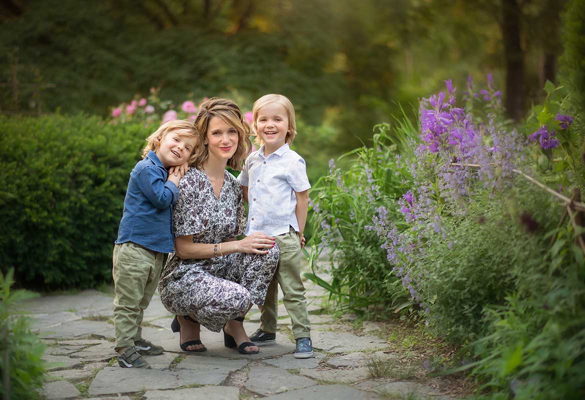 Happy mother smiling with her two boys in a garden