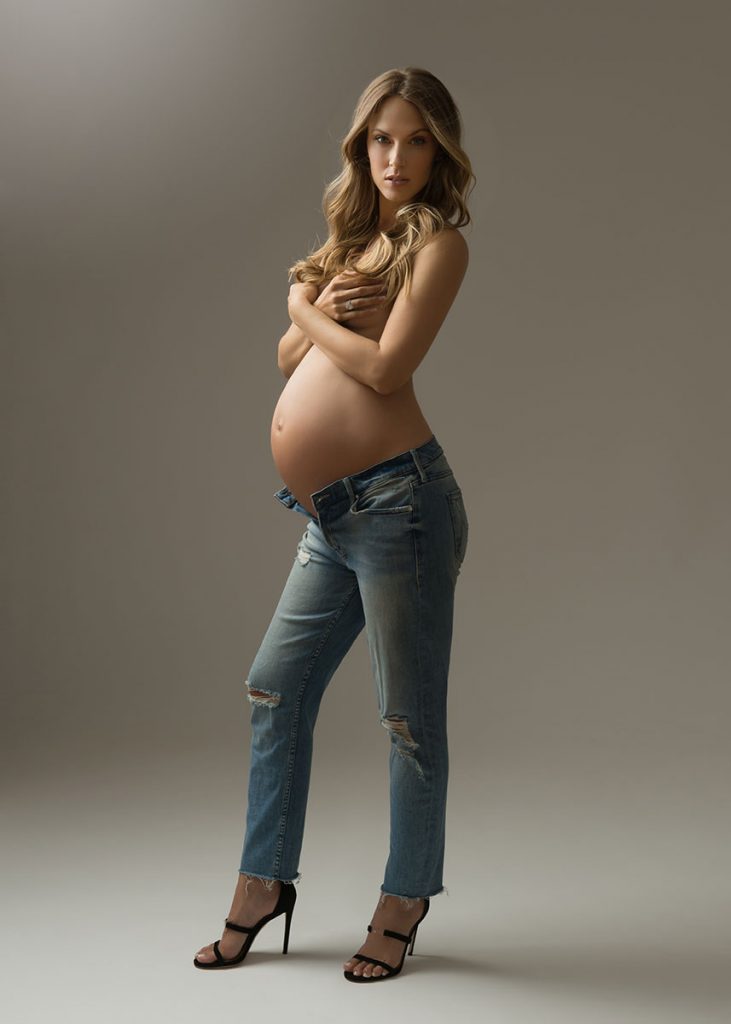 Expectant mom in jeans posing for a maternity portrait