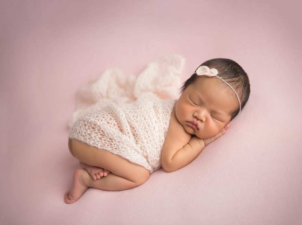 Sleeping baby with a swaddle and headband