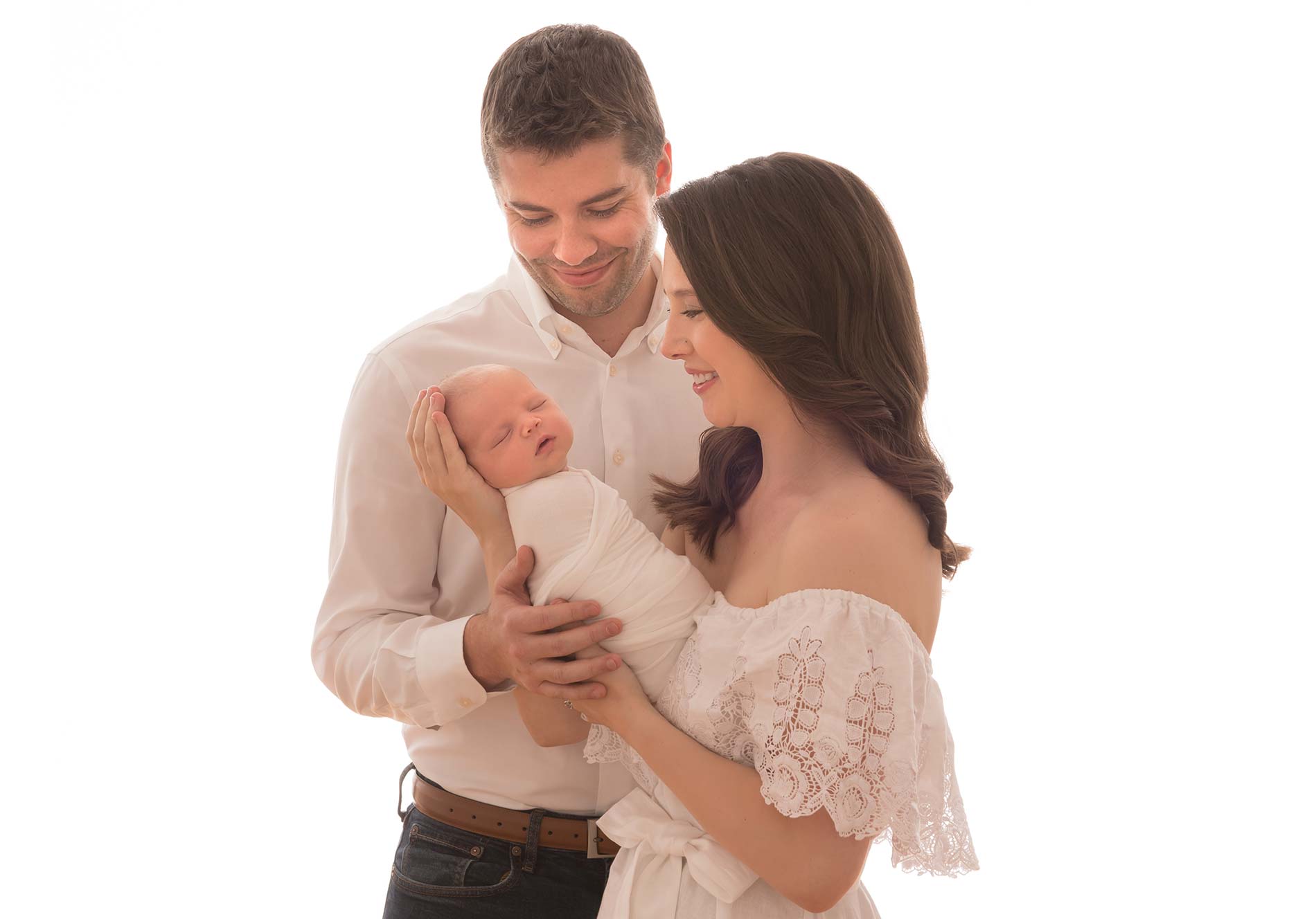 Family holding their newborn baby at a photo studio in NYC