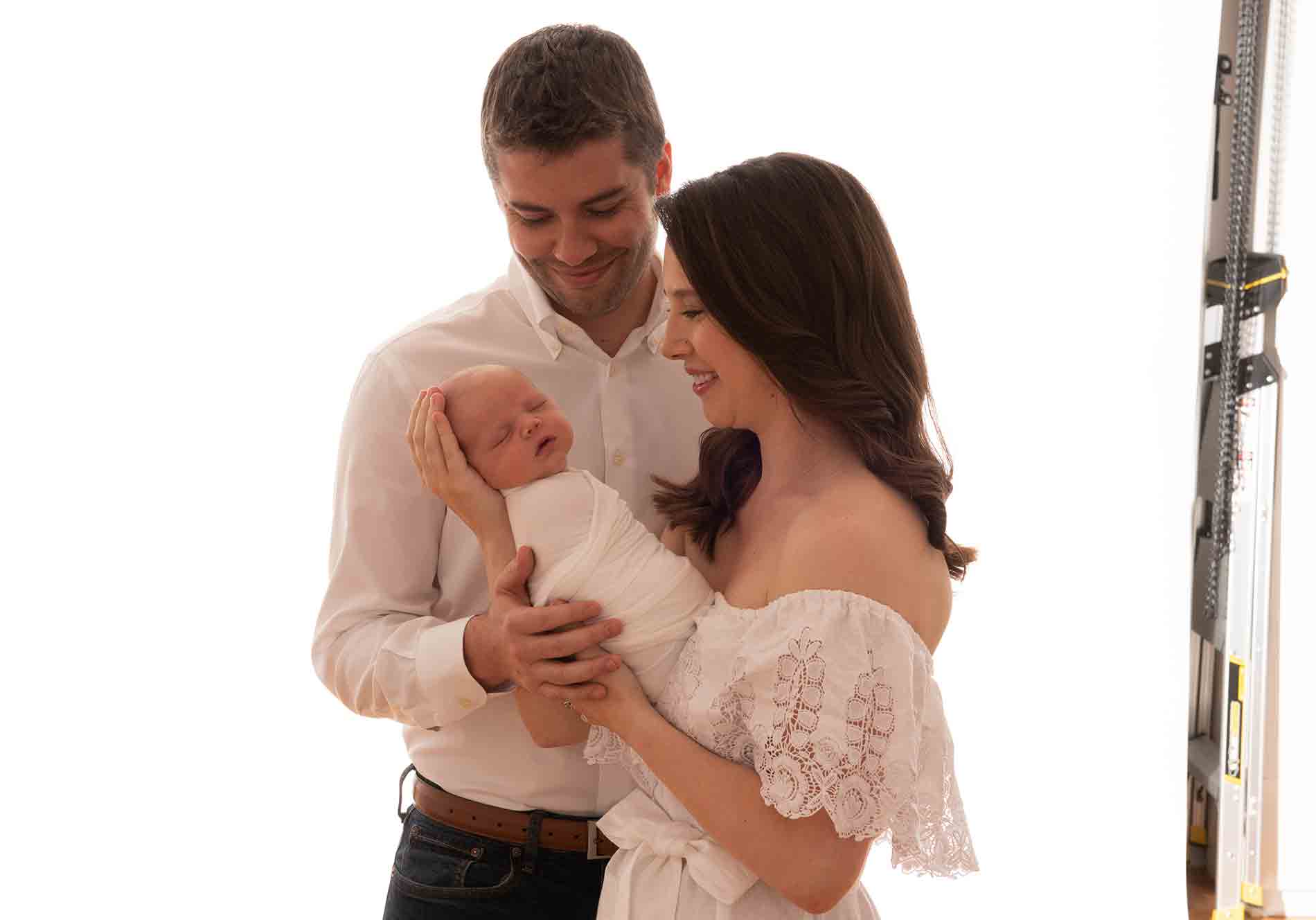 Family holding their newborn baby at a photo studio in NYC