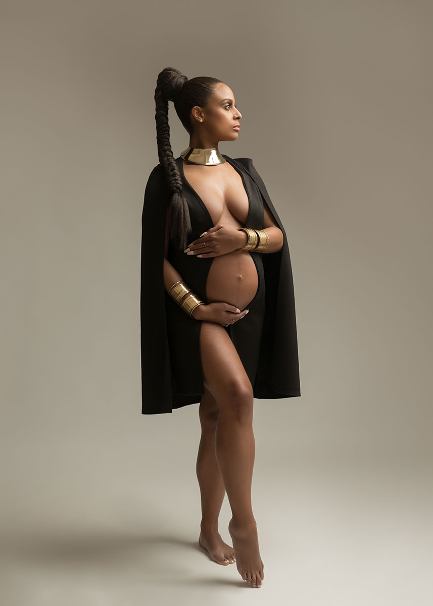 Black cape worn by a pregnant woman with a long braid at a NYC photography studio