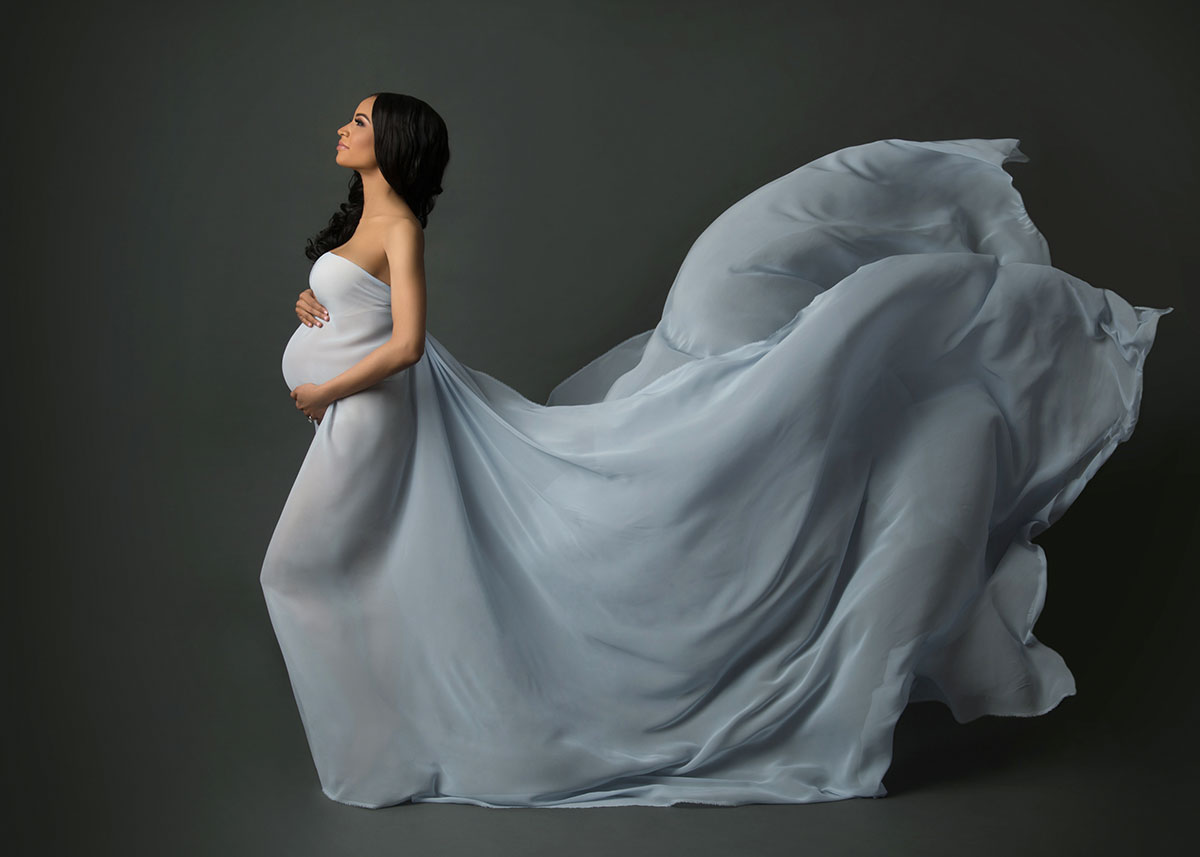 Flying blue fabric on a pregnant model