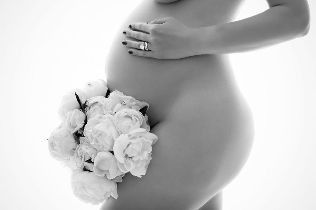 Pregnant belly with a flower bouquet