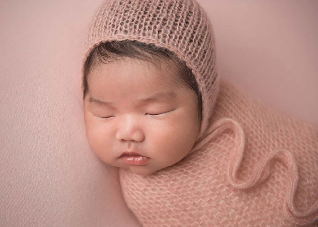 Sweet baby sleeping with a knit hat at a NYC photography studio