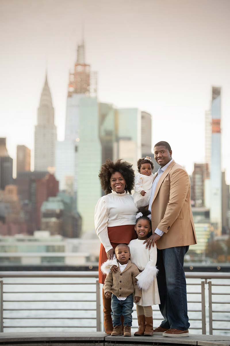 Stylish family posing for a portrait with NYC skyline