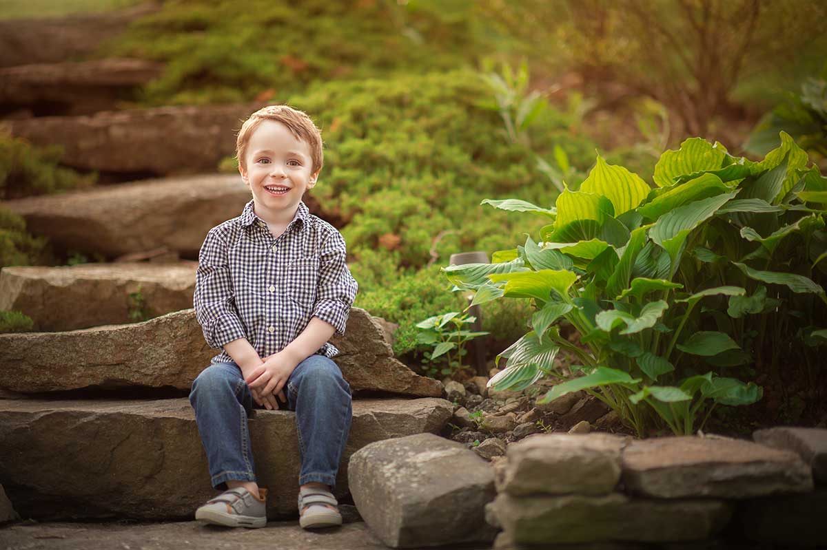 A happy boy smiling on a stone staircase in Central Park