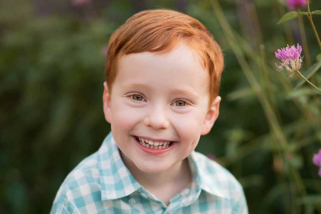 A boy with red hair smiling for the camera