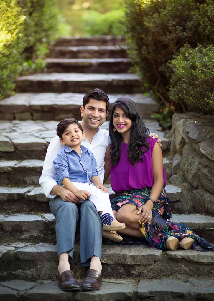 Parents share a smile with their little son on a stone staircase in NYC's Central Park