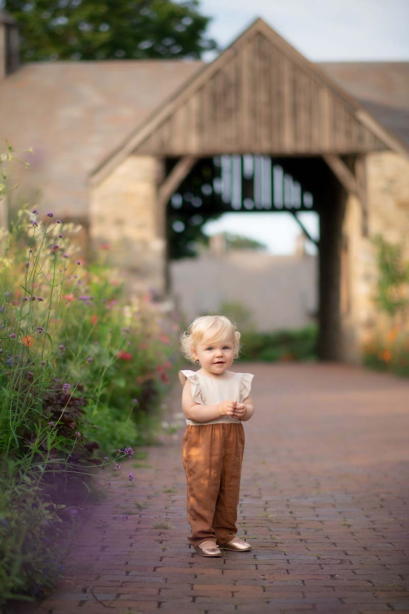 Adorable little girl standing on a brick path at a farm in Easthampton
