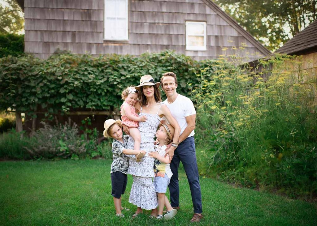 A modern family portrait with stylish parents taken in the Hamptons