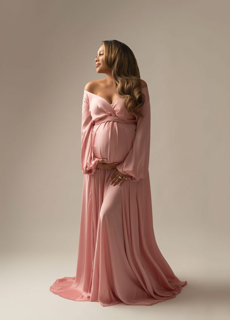 Stunning pink dress worn by a maternity model