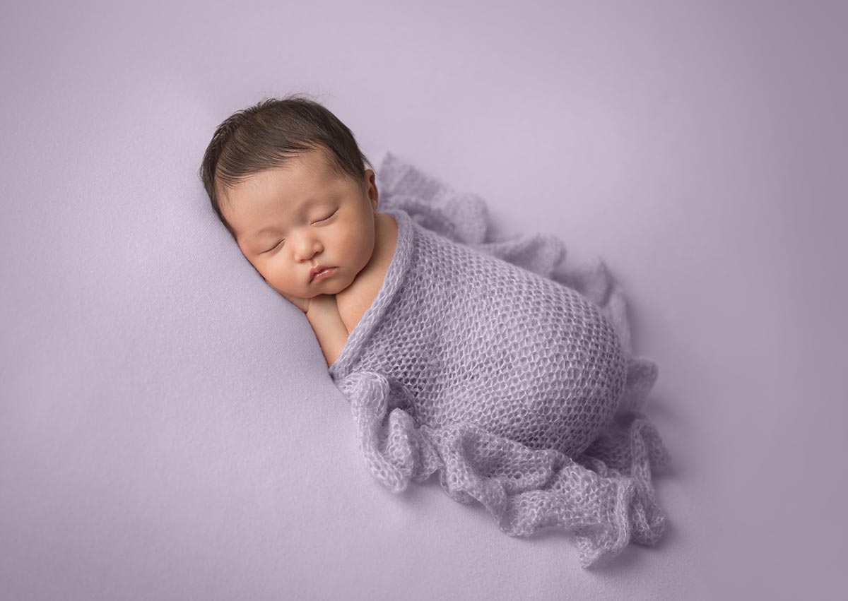baby sleeping on lilac purple blanket with ruffle knit lavender wrap
