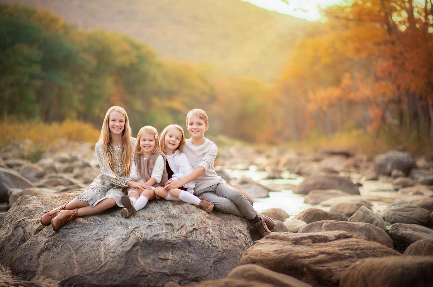 Stunning portrait of children set amidst Vermont foliage near a river