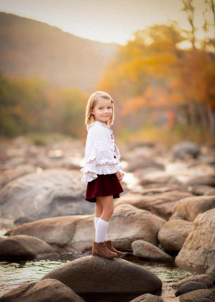 Girl standing on a rock near a river