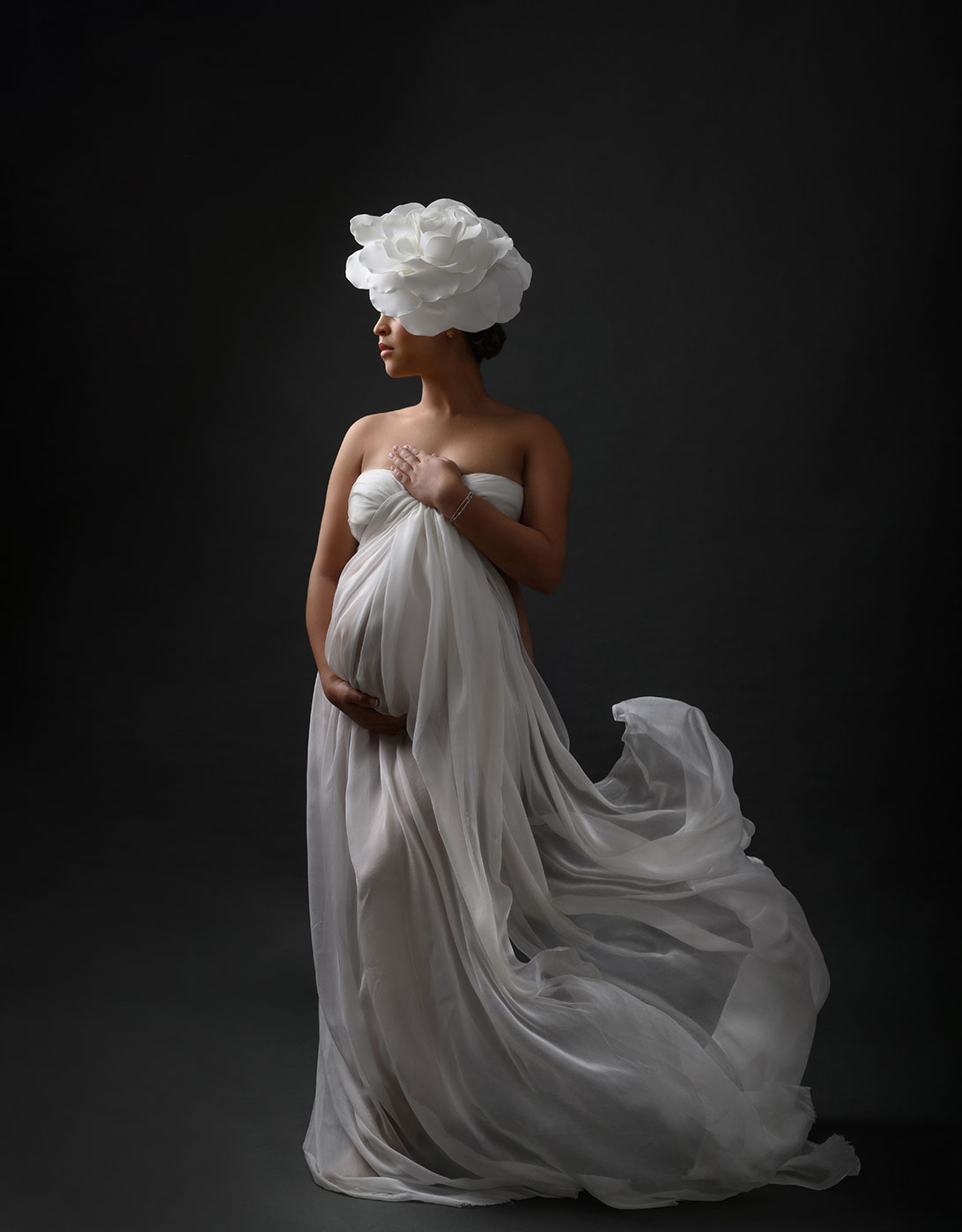 fine art maternity photography with flowing white silks and floral accessory