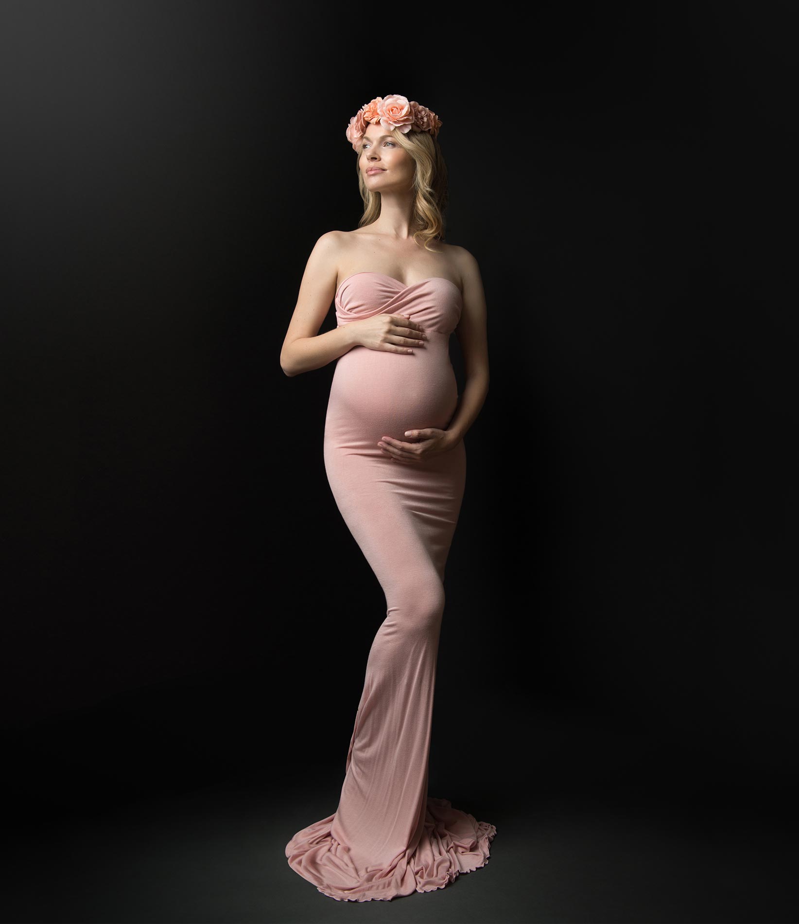 Pregnant woman in a pink dress and flower headband