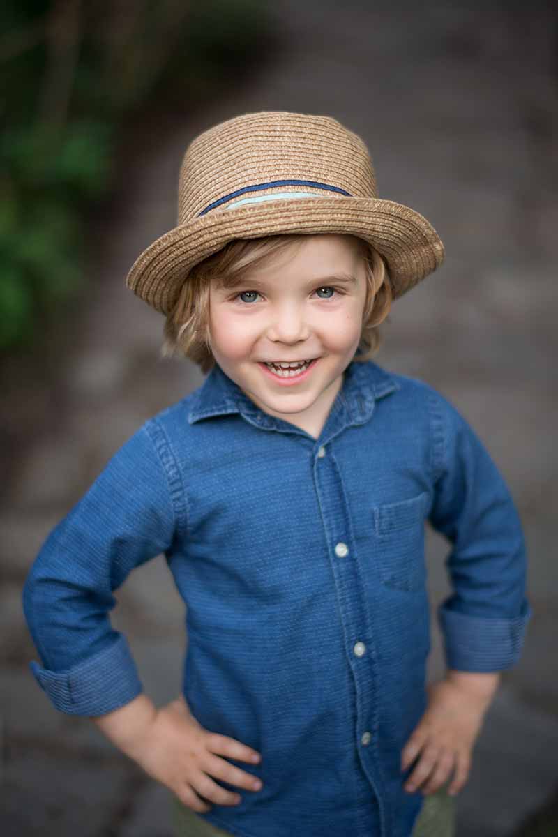 Young boy wearing a fedora smiling happily
