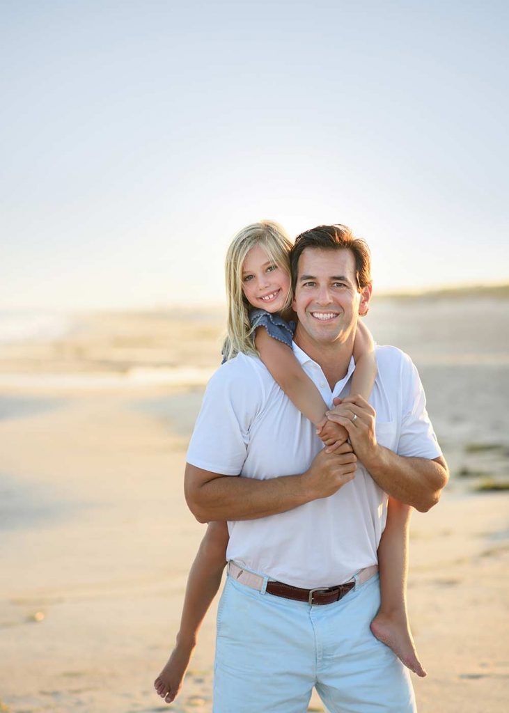 father-daughter-beach-sunset A girl getting a piggy-back ride on a beach